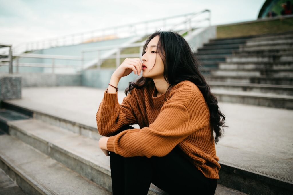 serious woman sitting outdoors on steps