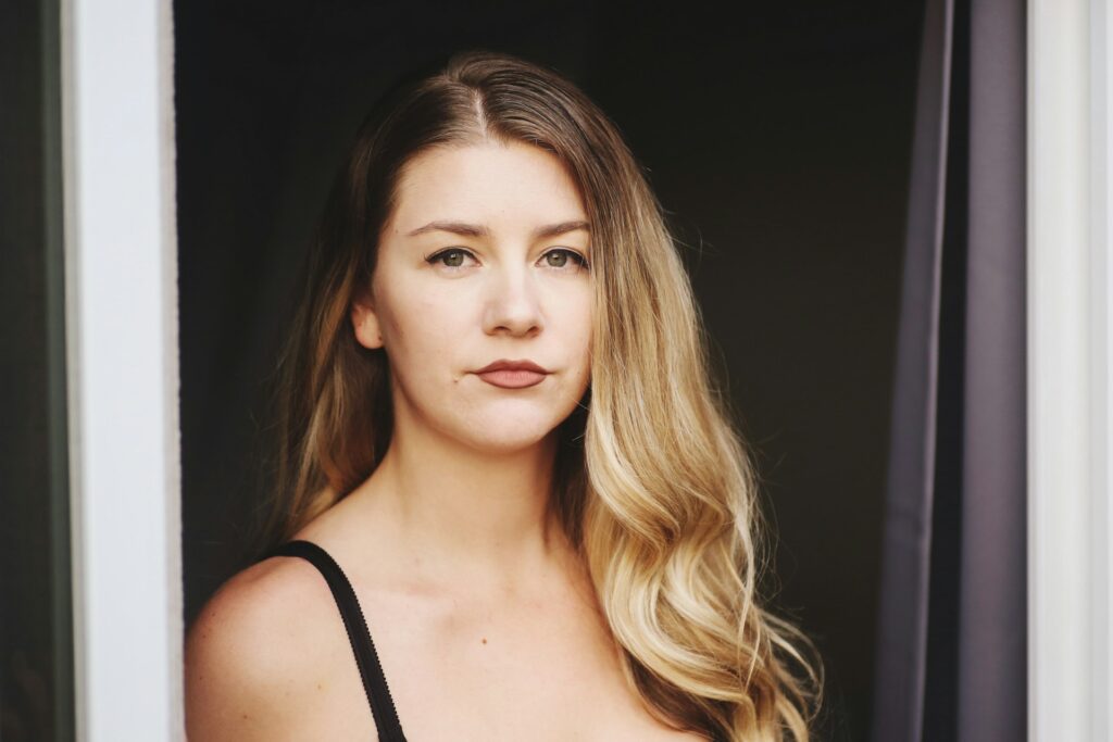 serious woman standing in doorway blonde hair