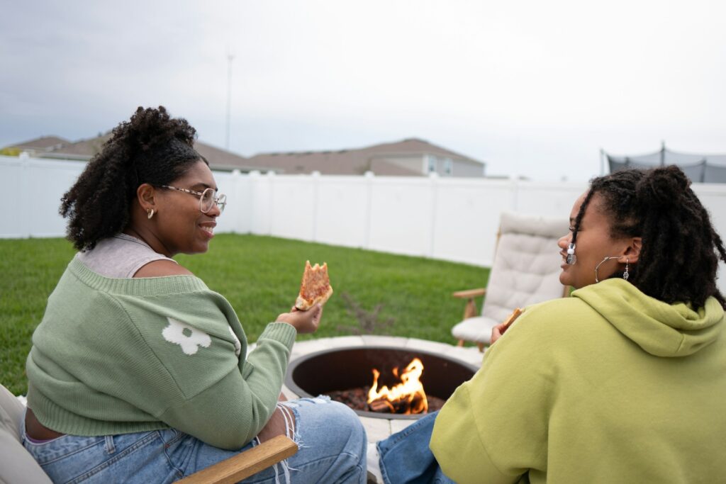 two women talking by fire